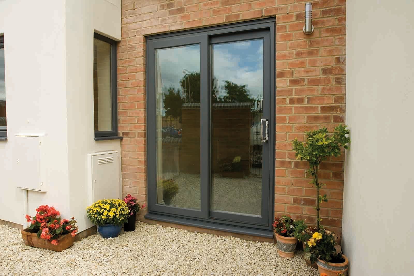 A sliding glass door is on the side of a brick building.
