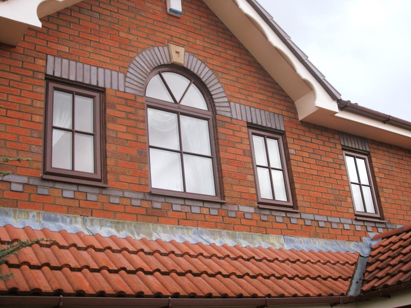 A brick building with arched windows and a tiled roof