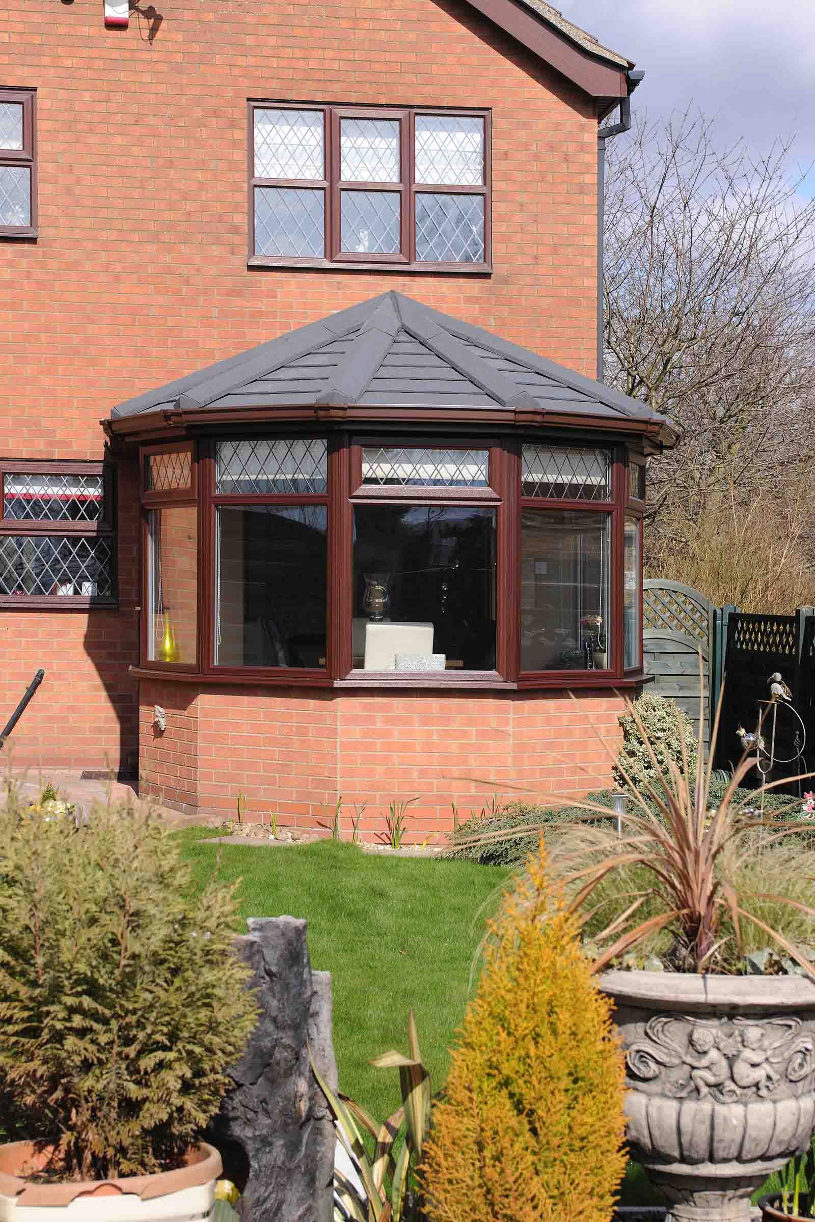 A brick house with a conservatory in the backyard