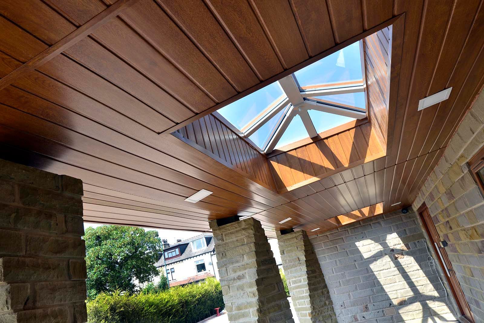 A wooden ceiling with a skylight in the middle of it