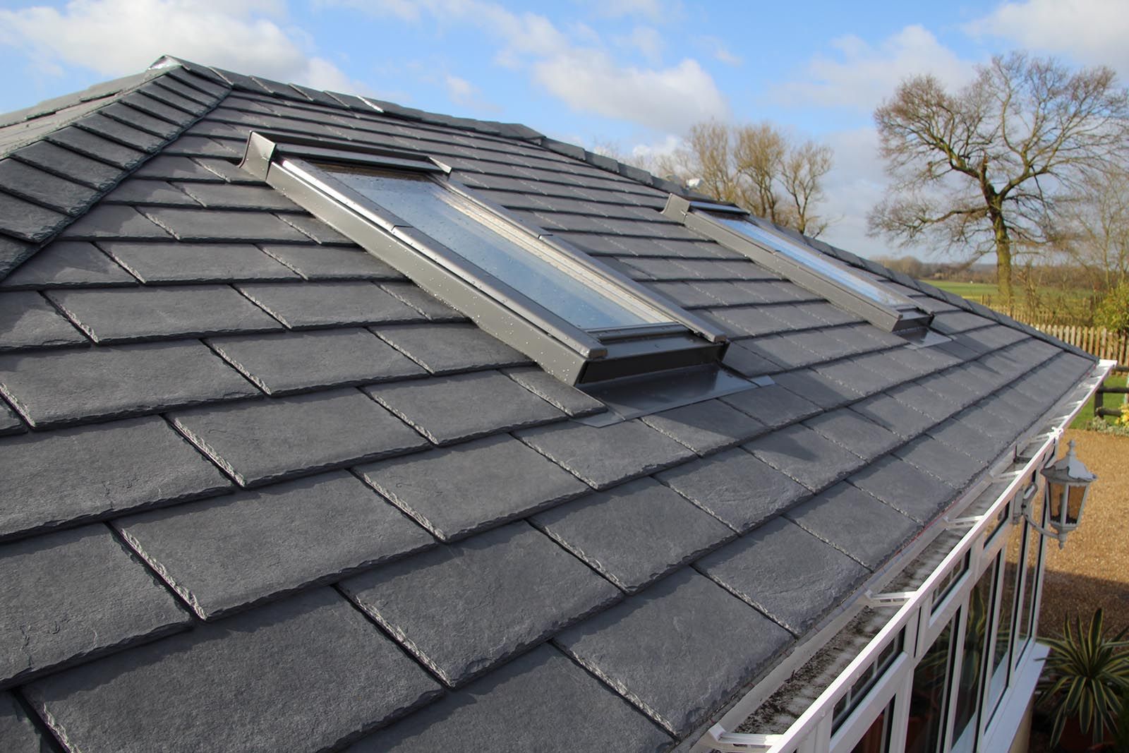 The roof of a house has two skylights on it