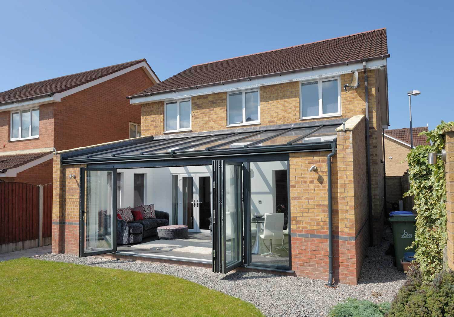 A brick house with a glass roof and sliding glass doors