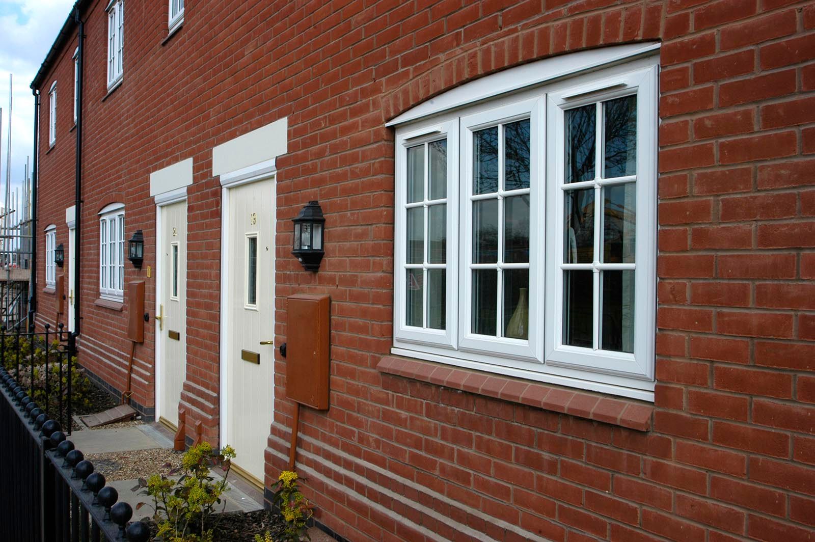 A row of red brick houses with white windows and doors.