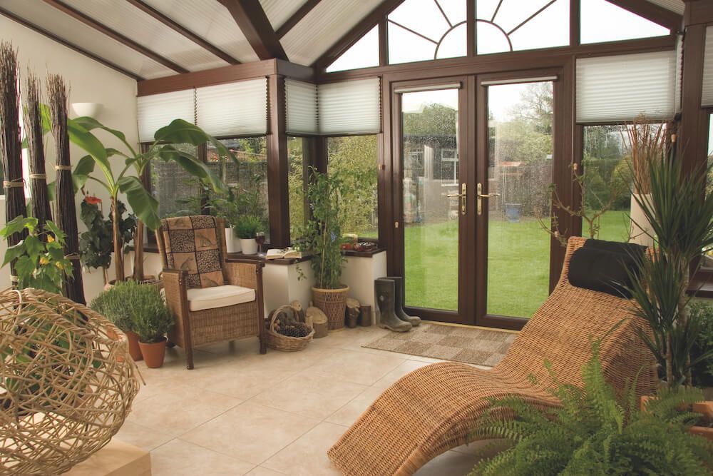 A living room with a wicker chair and a wicker chaise lounge