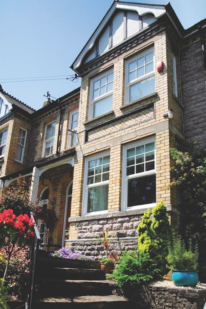 A large brick house with stairs leading up to the front door