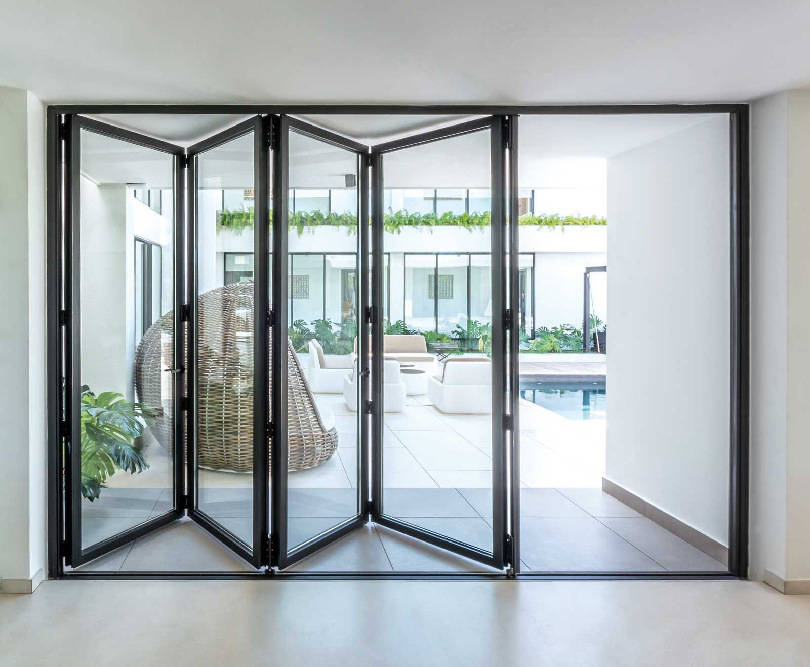 A room with a lot of glass doors leading to a patio.