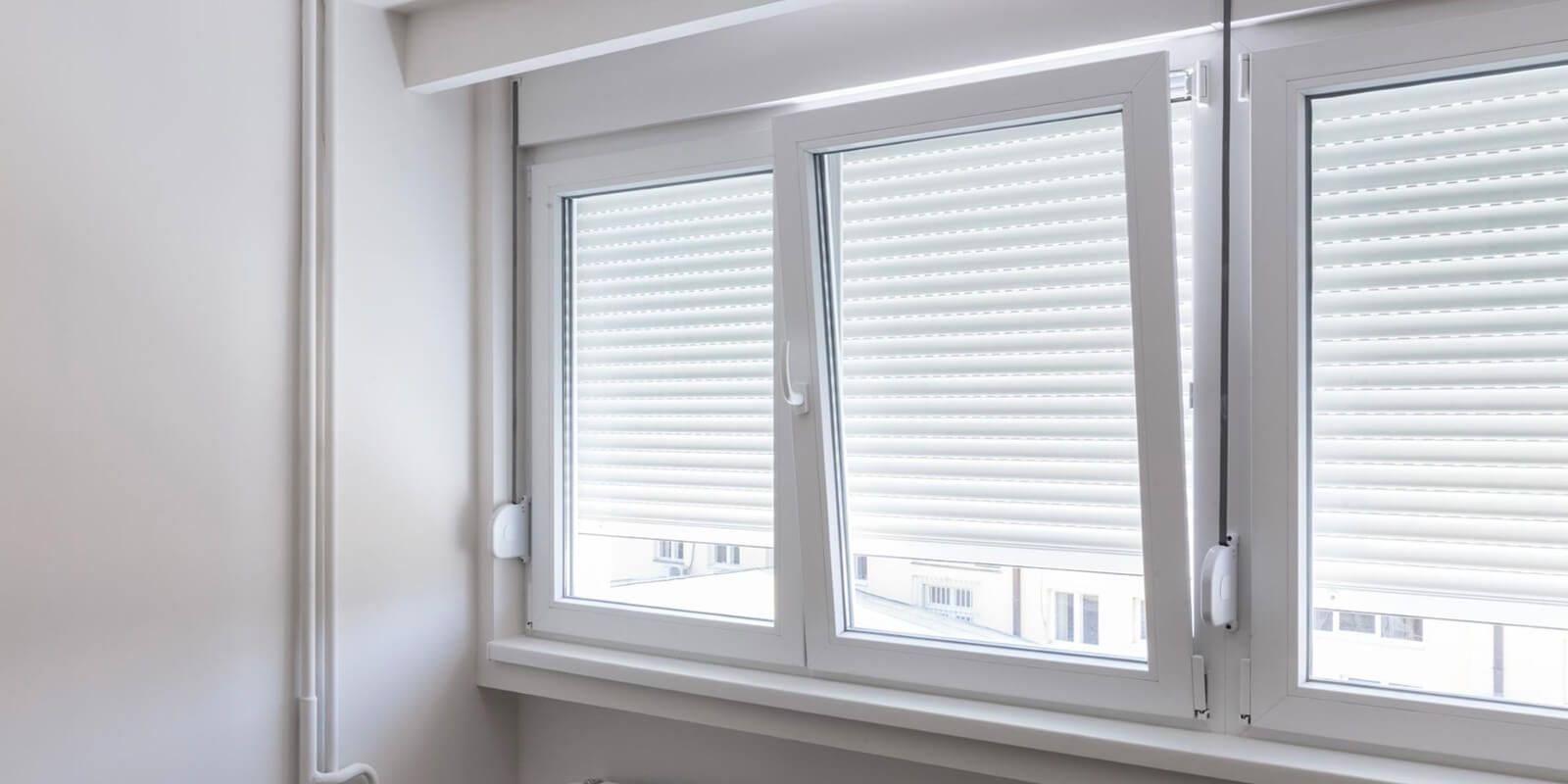 There are three windows with shutters on them in a room.
