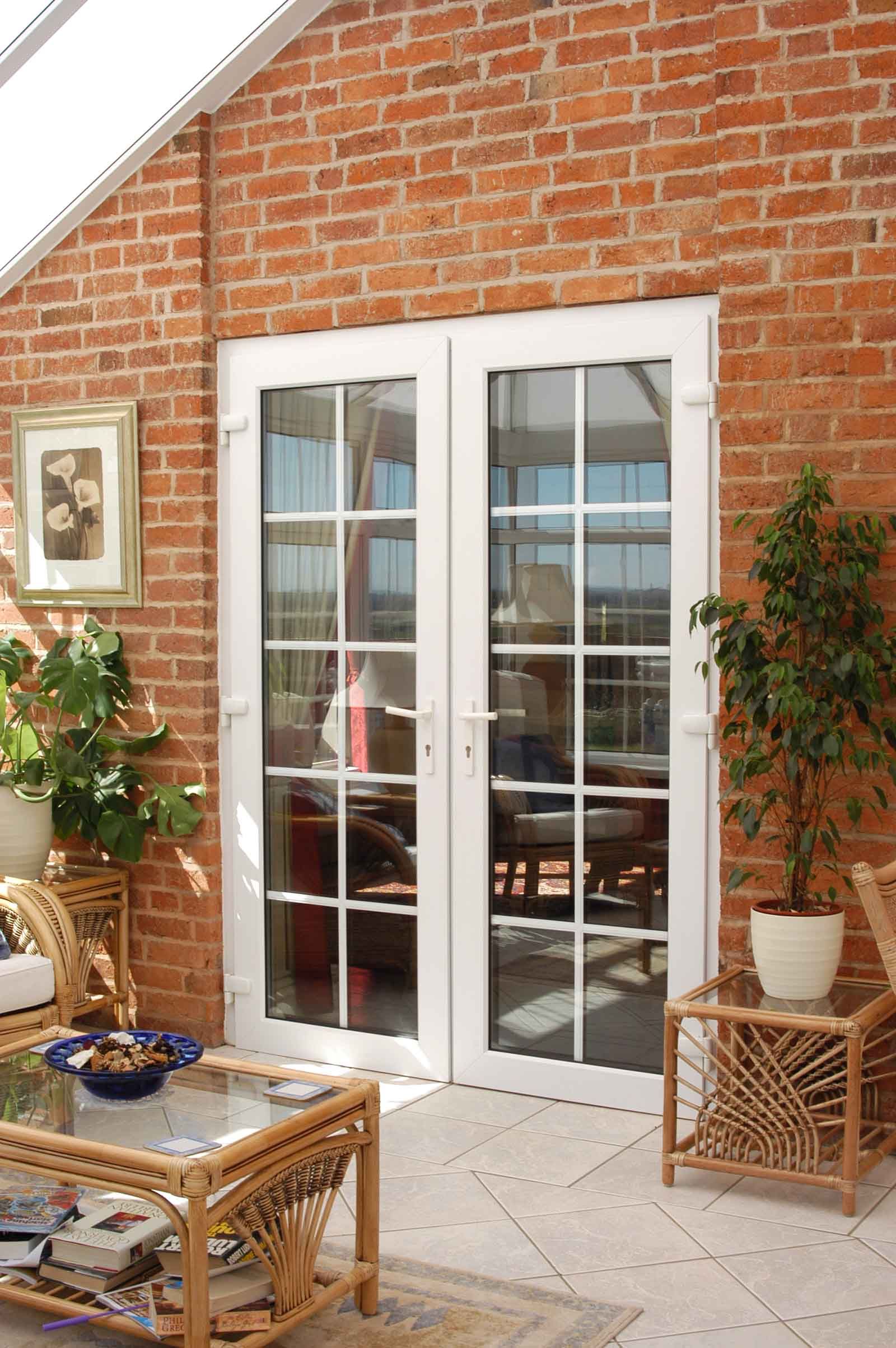 A living room with a brick wall and white french doors