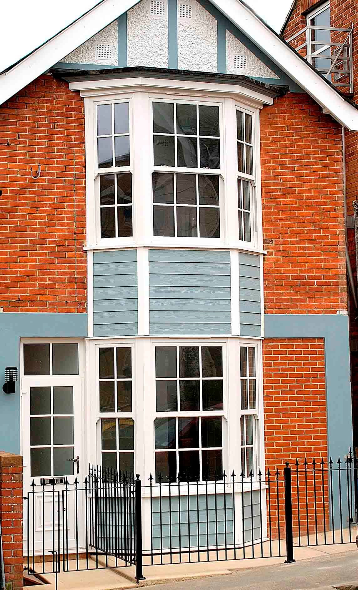 A red brick house with blue trim and white windows