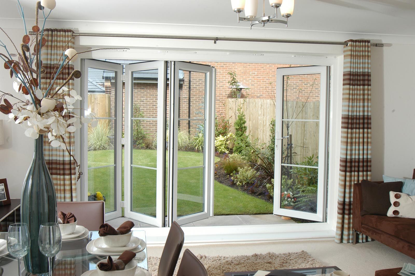 A living room with a dining table and chairs and a sliding glass door leading to a garden.