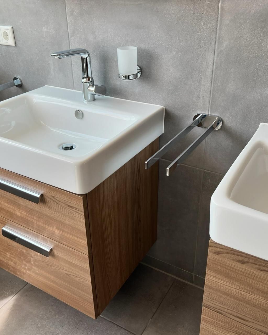 Ein Badezimmer mit zwei Waschbecken und einem Holzschrank