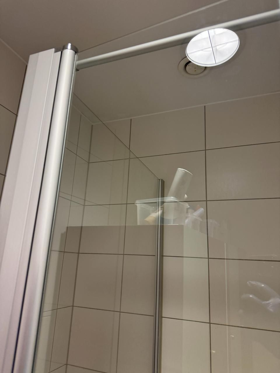 Eine Dusche mit Glasschiebetür und Duschkopf