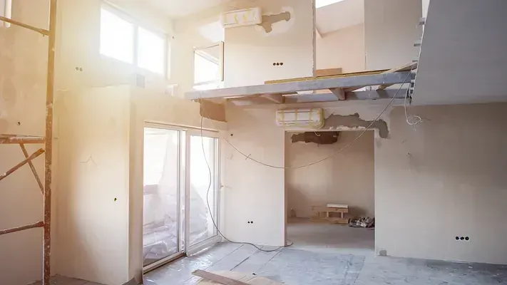 Una habitación vacía en una casa en construcción con una puerta corrediza de vidrio.