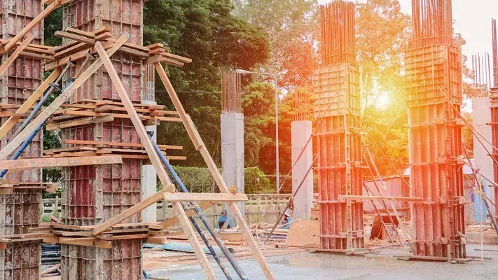 Un sitio de construcción con muchos pilares de madera y andamios.