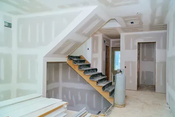 Se está construyendo una escalera en una habitación con paredes de yeso.