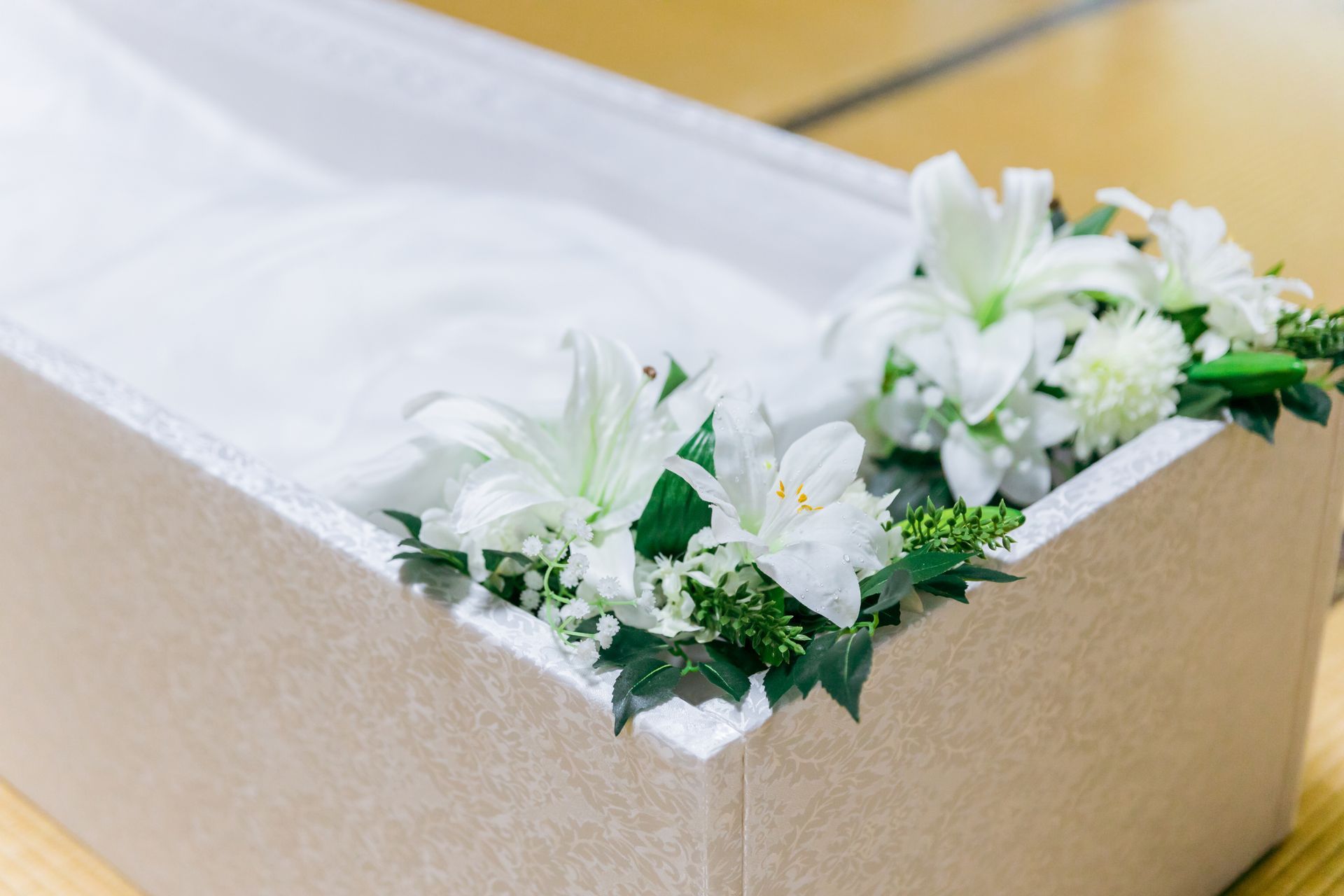 Cercueil blanc ouvert avec des fleurs blanches