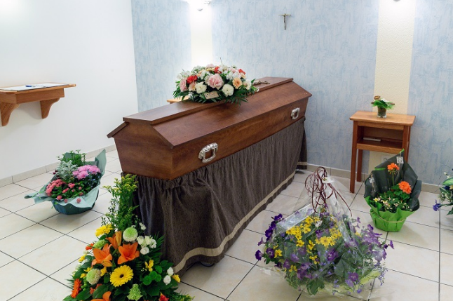 Cercueil fermé entouré de fleurs