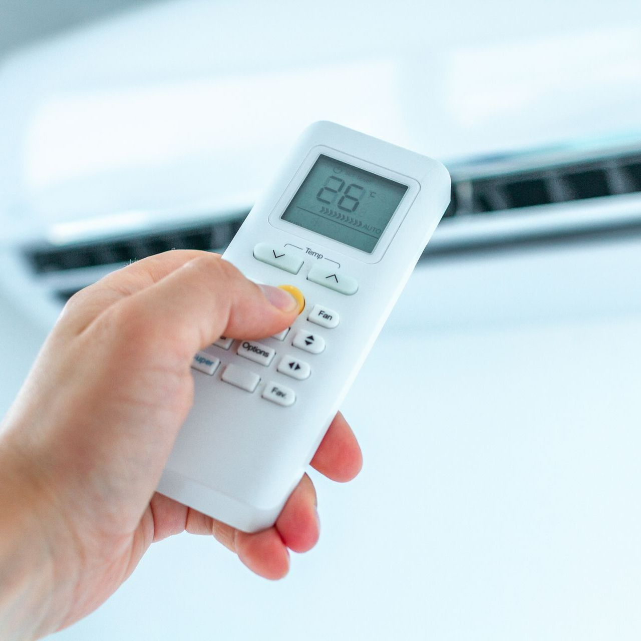 Une personne met en route un climatiseur