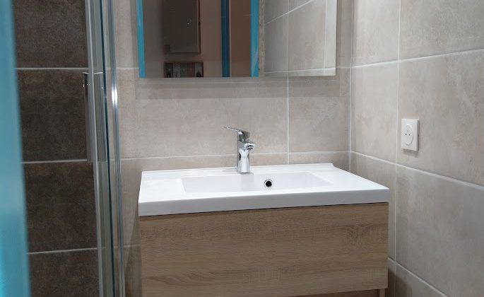 Un évier sur un meuble de salle de bains en bois clair