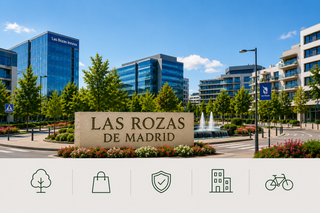 Mirador en una plaza con un edificio al fondo, con escalones de piedra y árboles altos bajo un cielo azul.