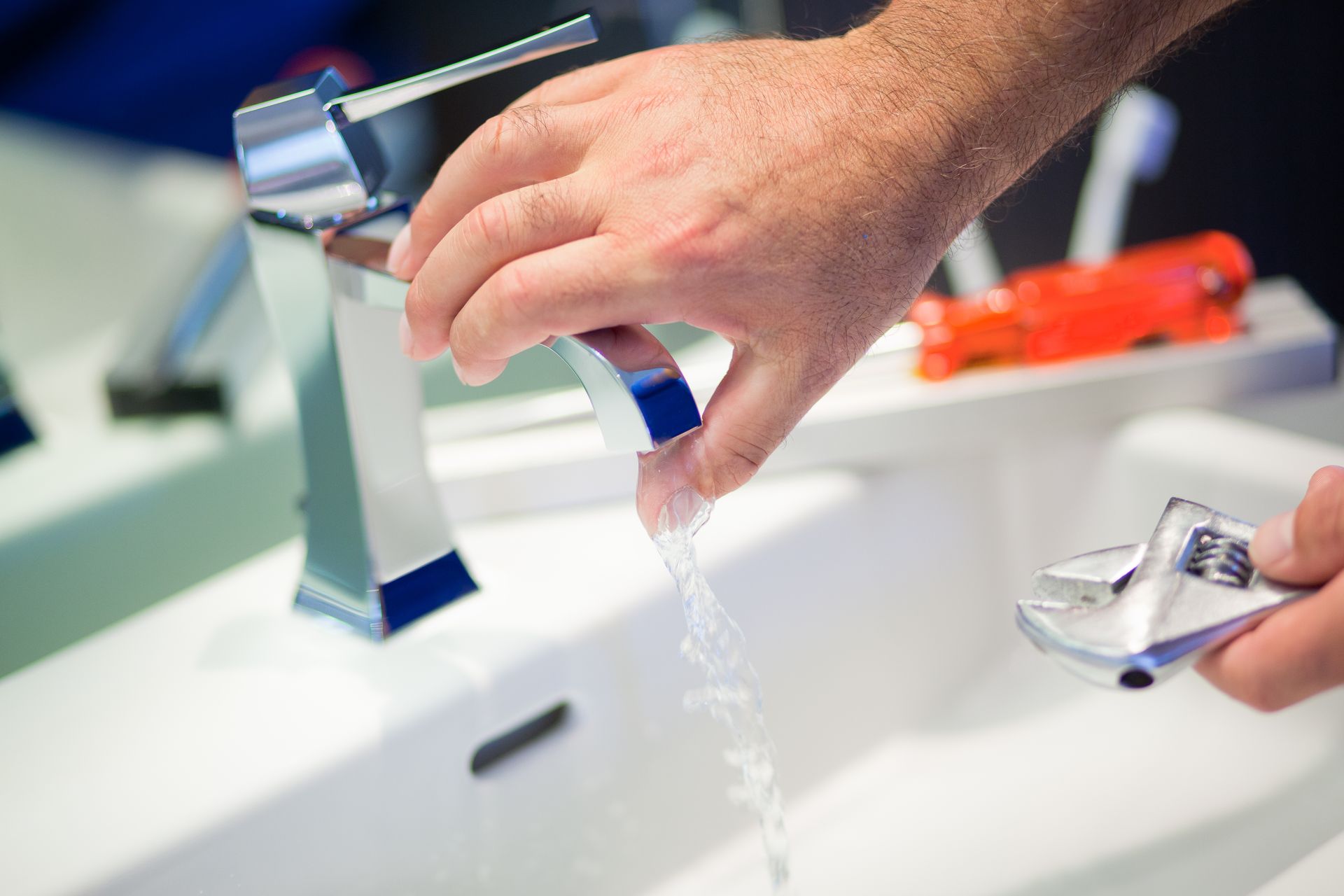 Badezimmer mit Waschtisch aus Holz, weissem Waschbecken, grossem Spiegel und Handtuchwärmer. Grauer Boden, gestreifter Teppich.