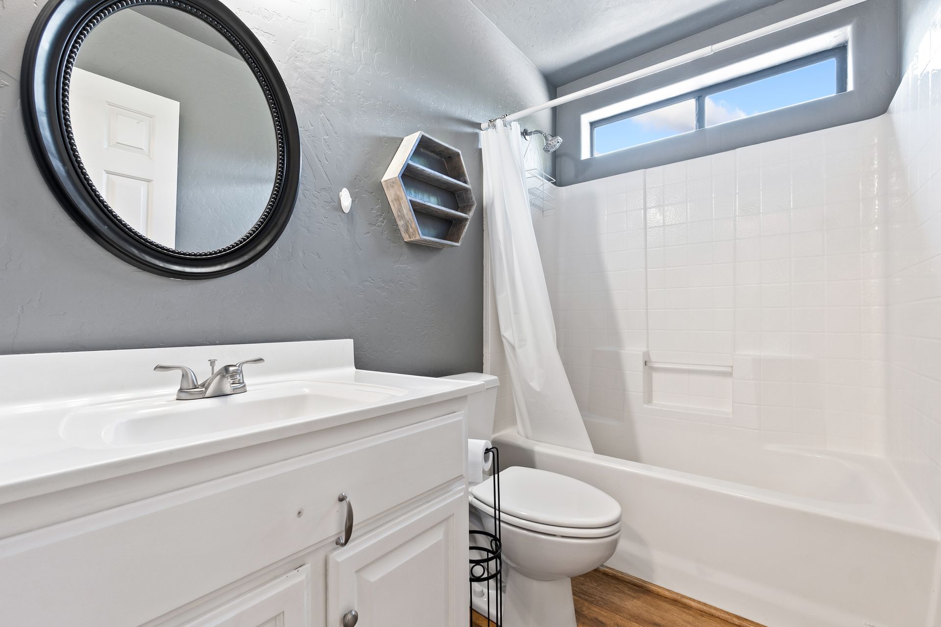 Badezimmer mit hellbraun gefliesten Wänden, Dusche, Toilette und Waschbecken.