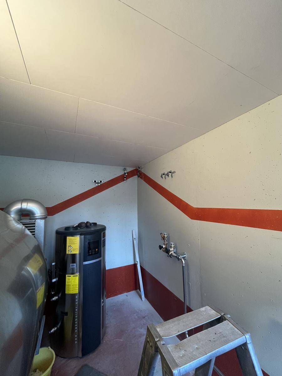 Hauswirtschaftsraum mit Warmwasserbereiter, roter Umrandung und Leiter.