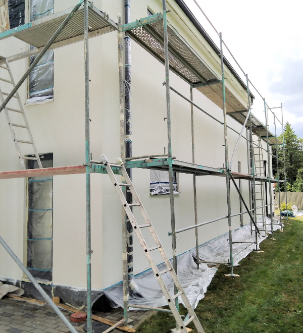 Peinture extérieure de la maison en cours, avec installation d'échafaudages.