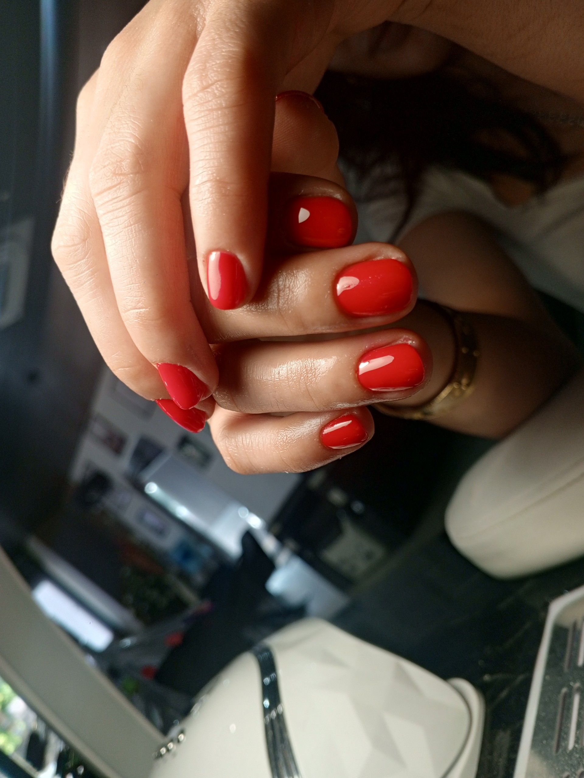 Un primer plano de las manos de una mujer con uñas rojas.