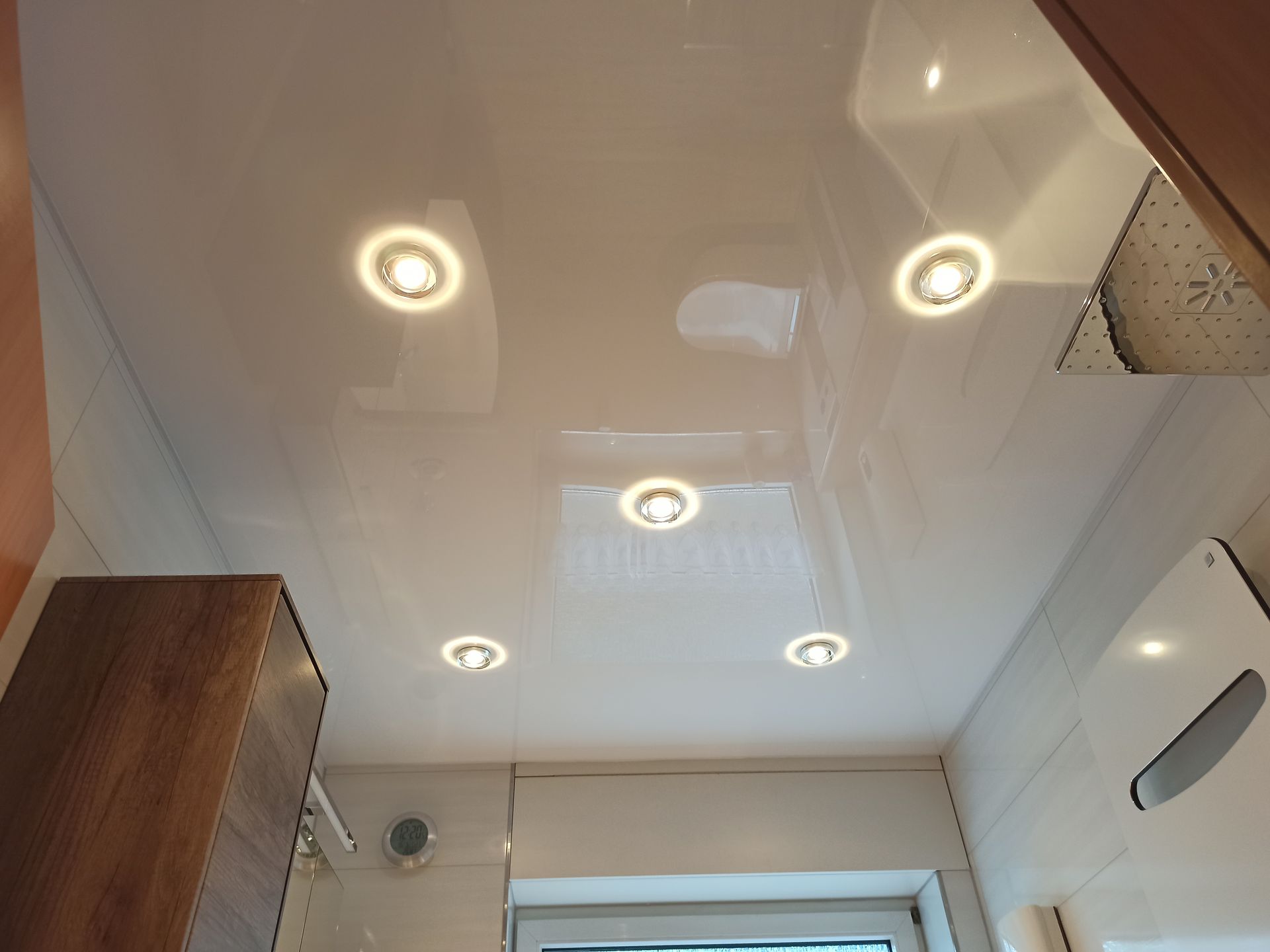 Fünf Lampen an glänzender Decke im Bad