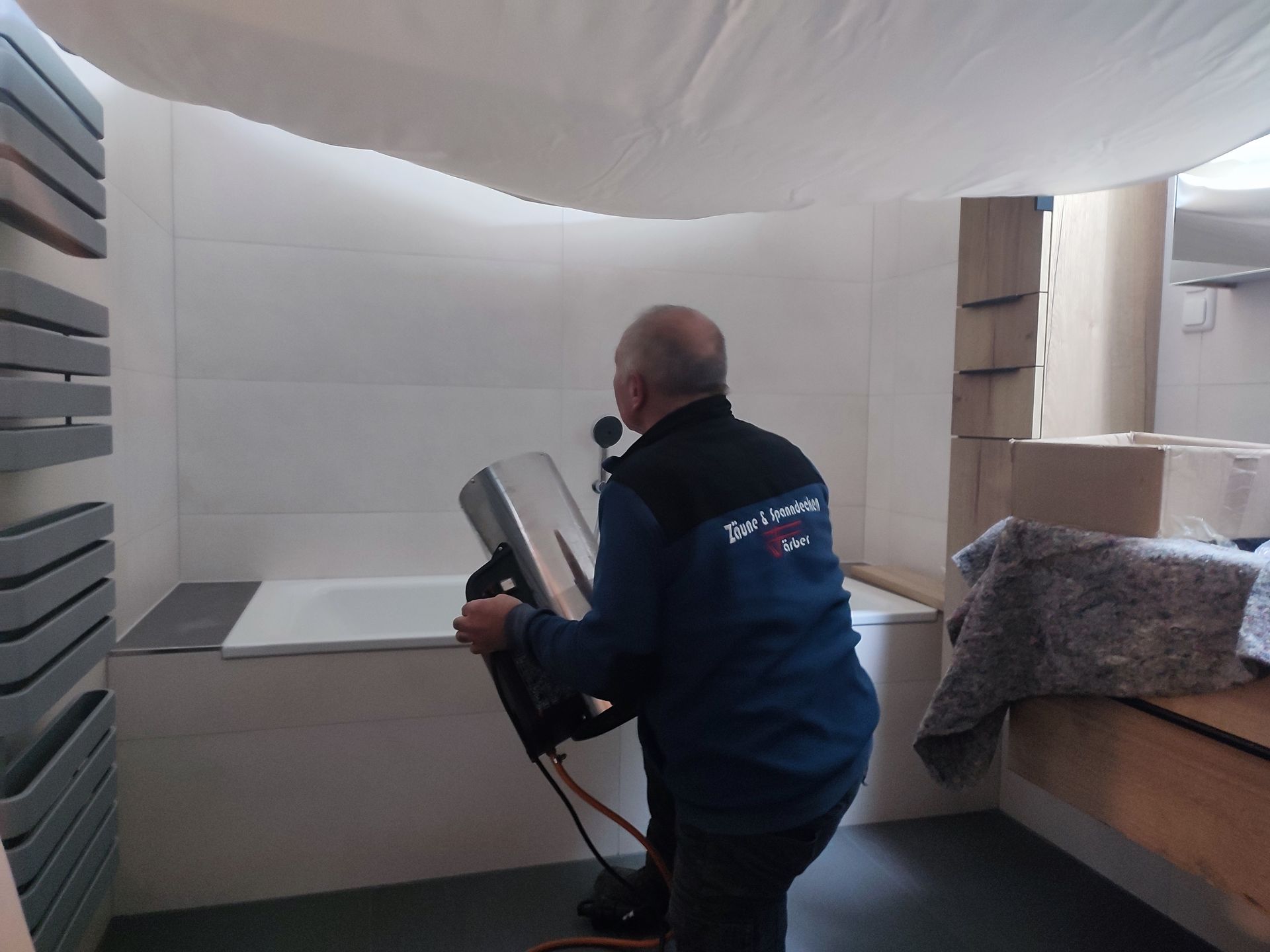 Mann nutzt Gerät, um das Badezimmer in Stand zu halten