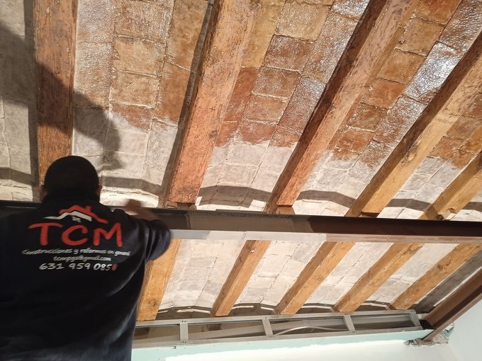 Un hombre está arrodillado en el suelo en una habitación con una canasta en el suelo.