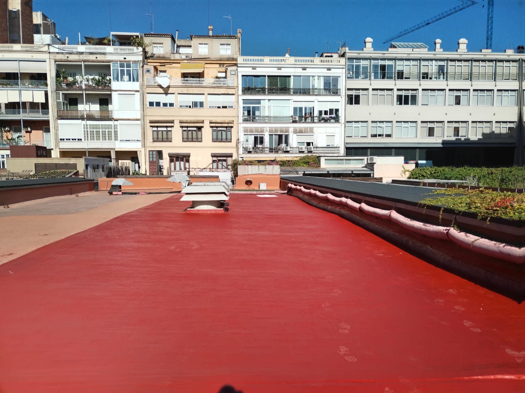 Un techo rojo con muchos edificios al fondo.