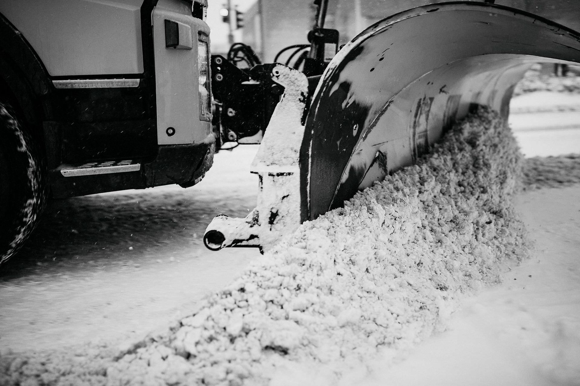 Kuorma-autosta työnnetään lunta lumiselle tielle, jonne muodostuu lumivalli.