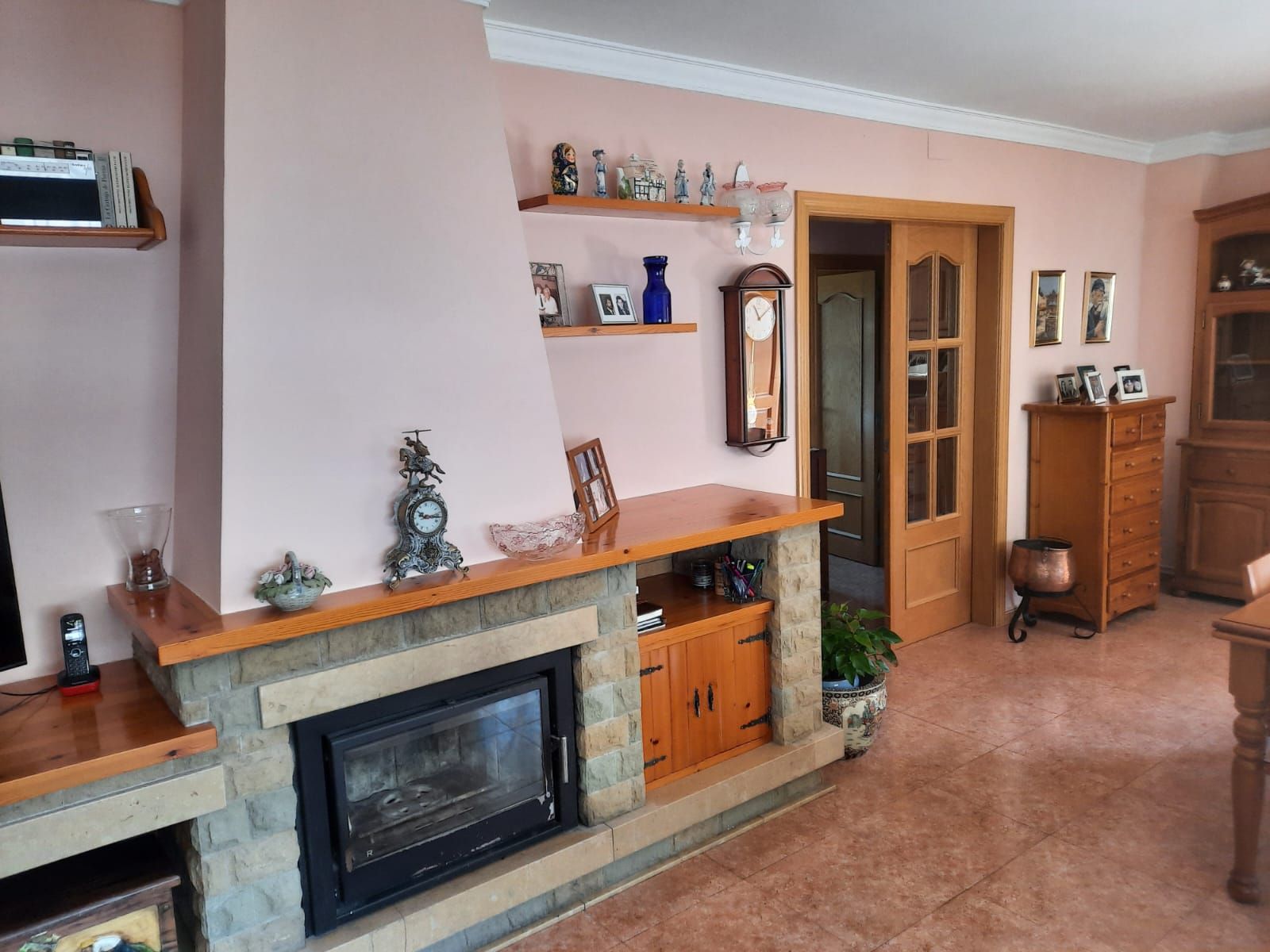 Una sala de estar con chimenea y un reloj en la pared.