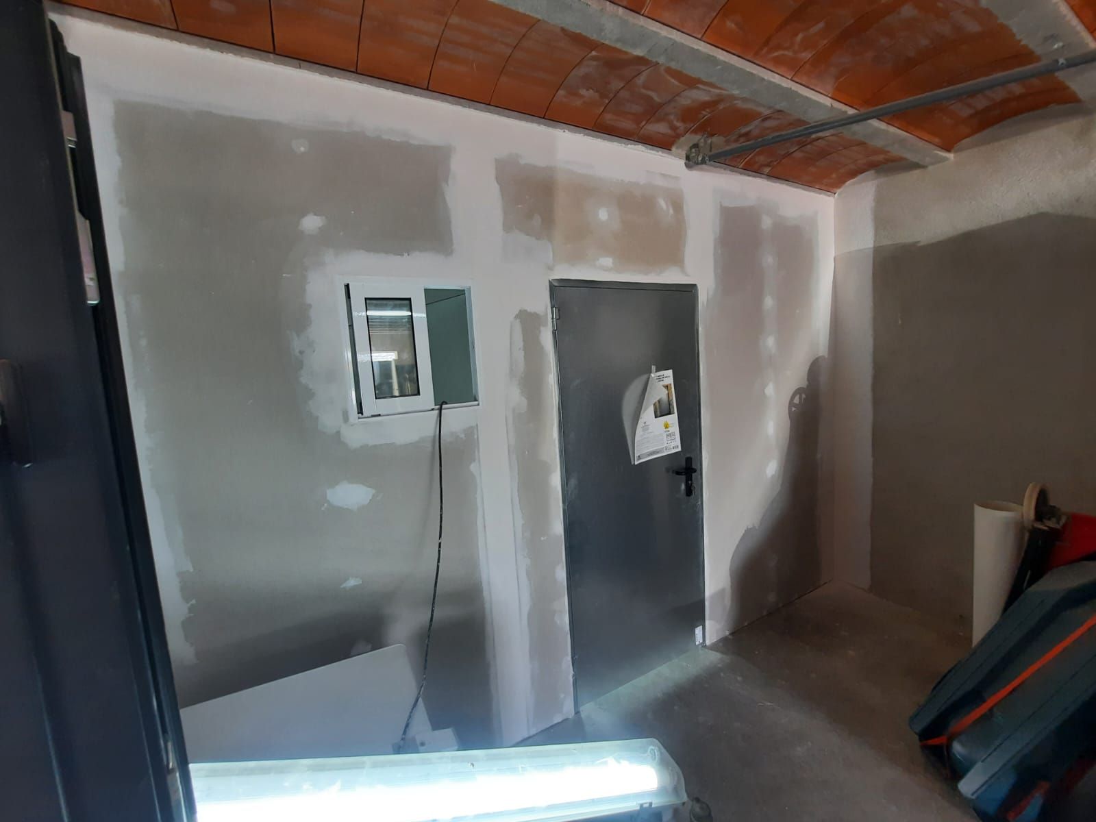 Una habitación con una puerta y una luz en la pared.