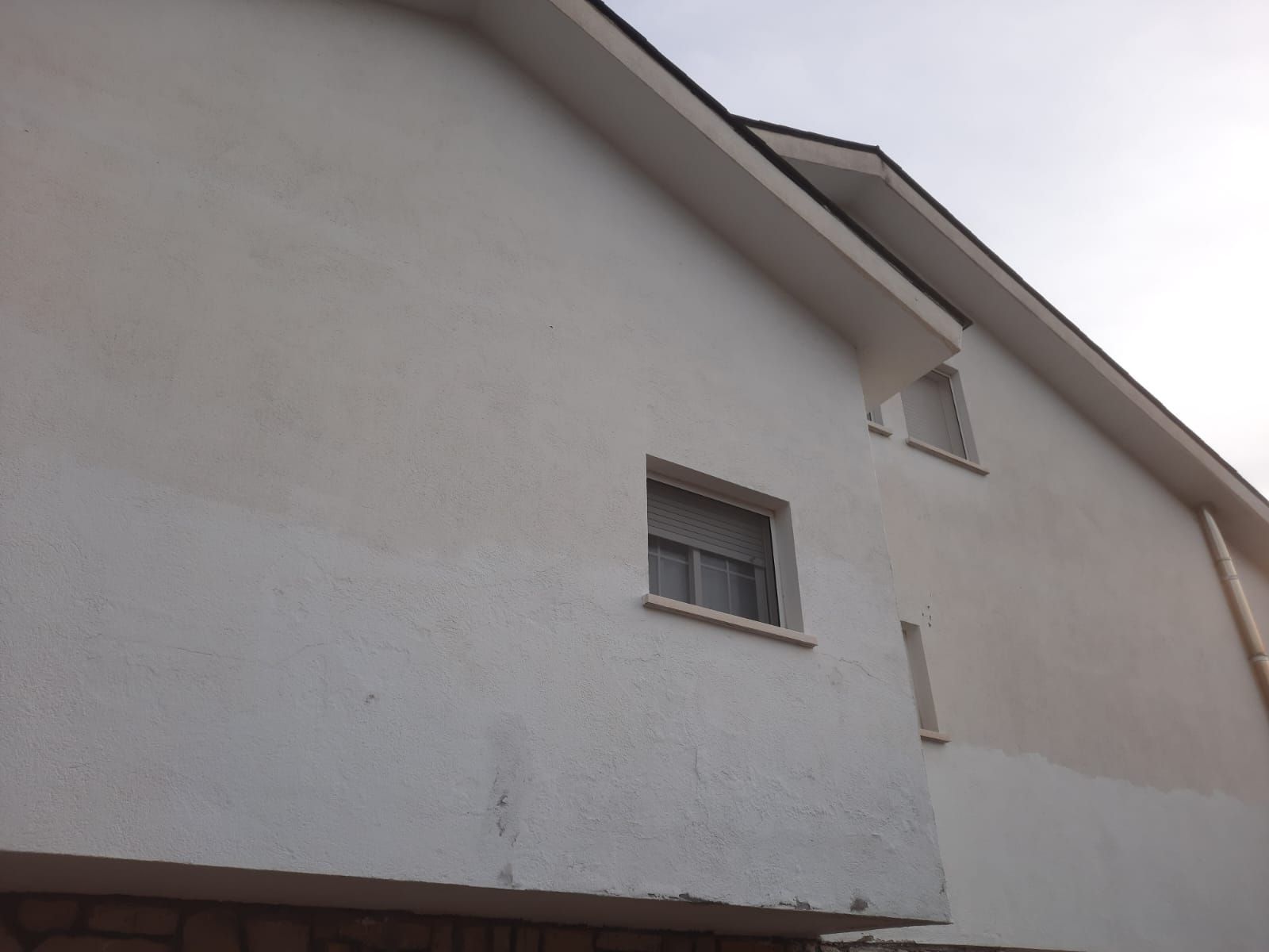 Un edificio blanco con una ventana en el lateral.