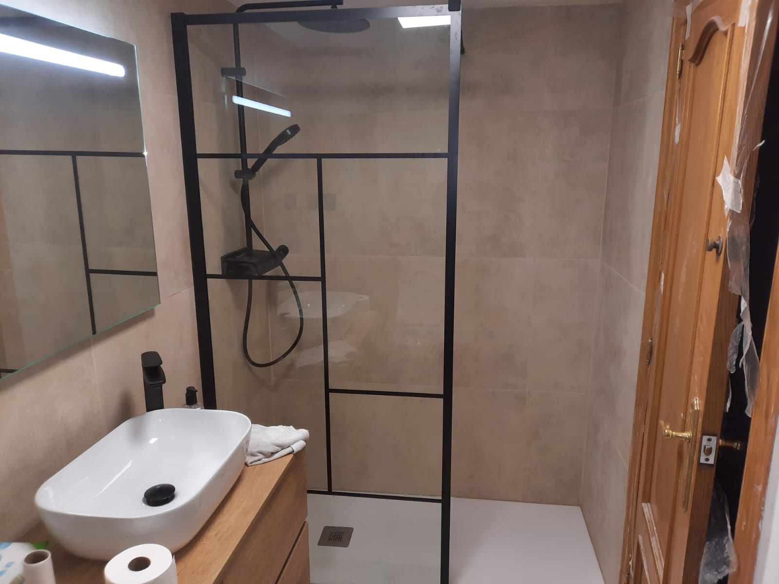 Un baño con lavabo y ducha a ras de suelo.