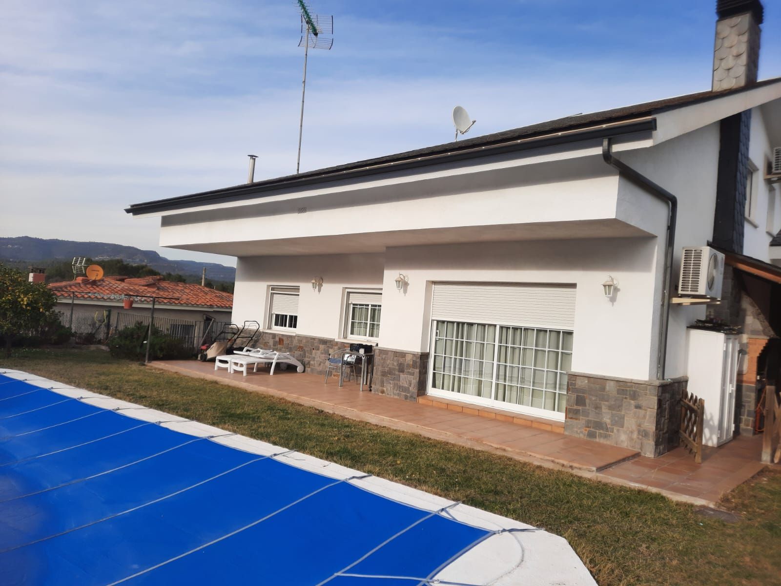 Una casa blanca con una piscina azul delante de ella