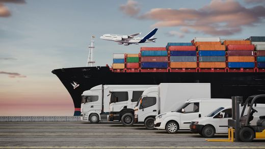 Camions de marchandises près d'un porte-conteneurs, avec un avion survolant la zone au coucher du soleil