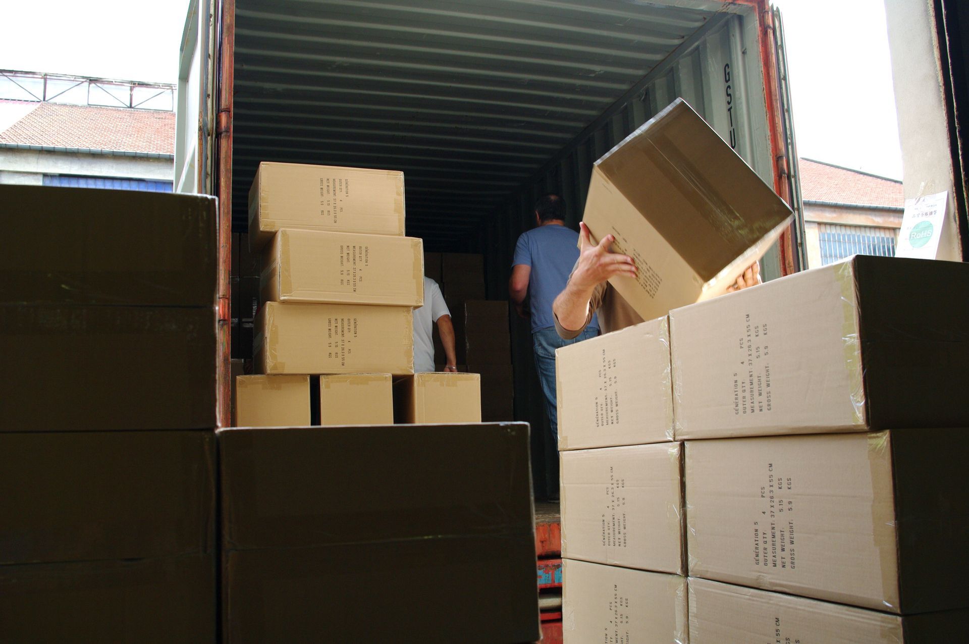 Une personne charge des cartons dans un conteneur d'expédition