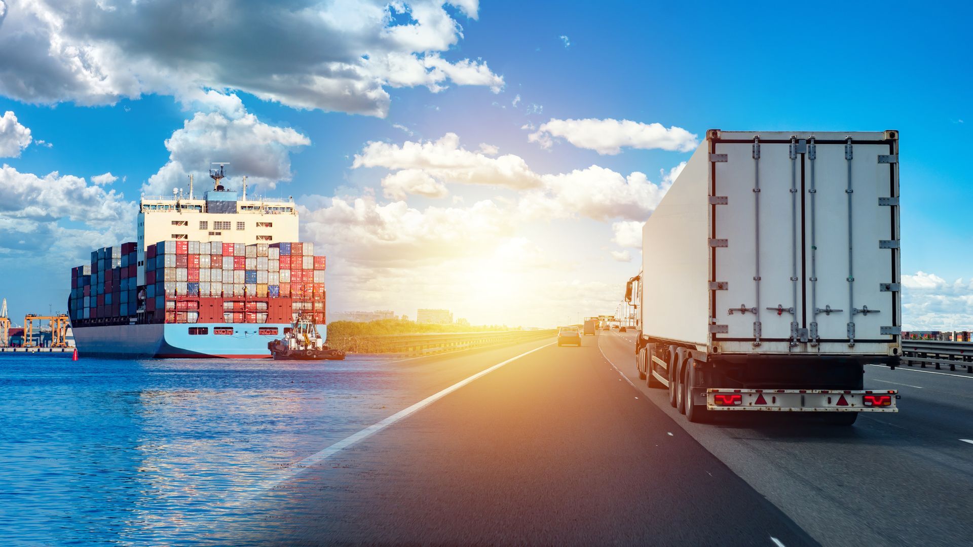 Cargo et camion sur une route du front de mer au coucher du soleil, sous un ciel lumineux et une eau bleue