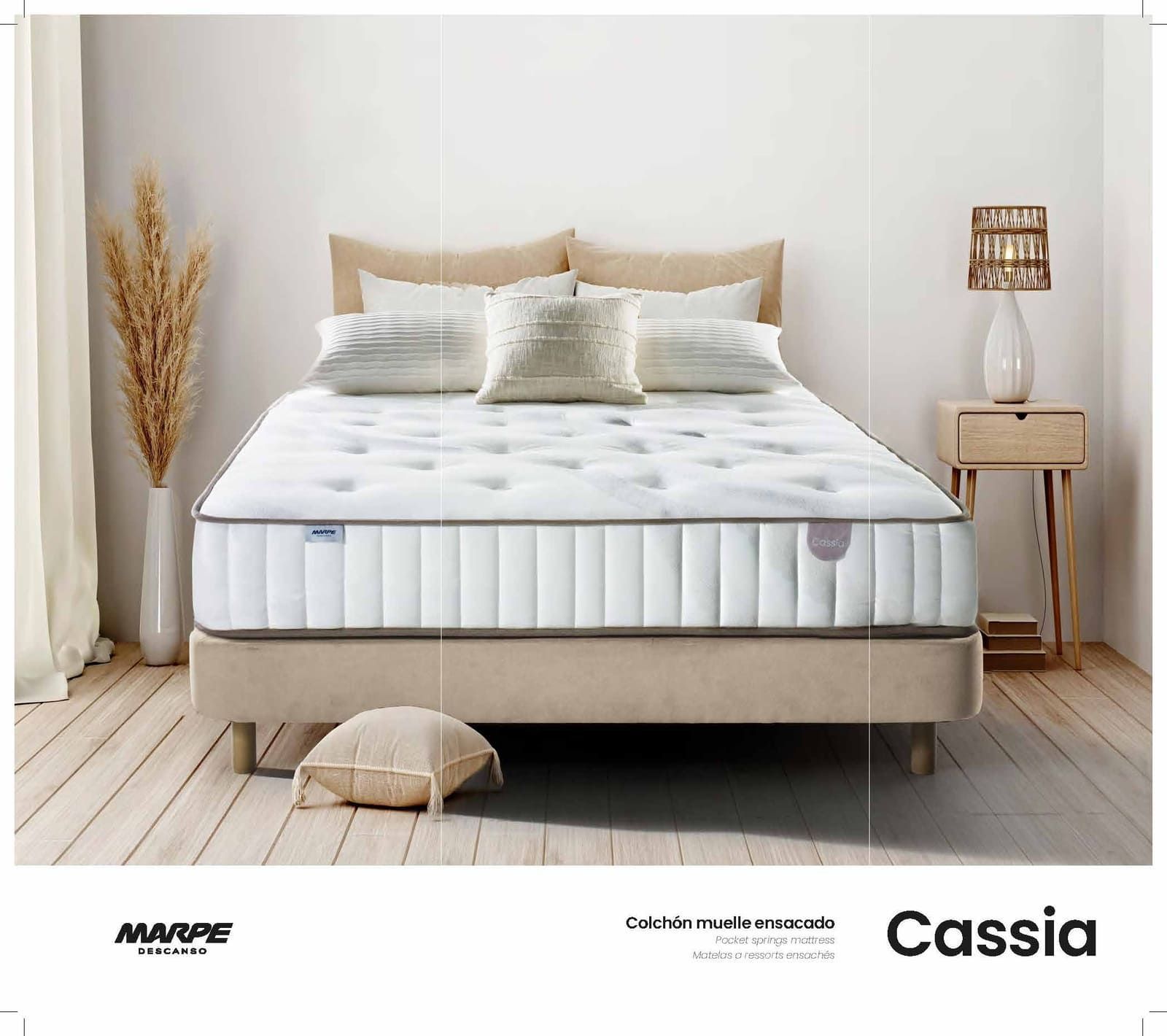 Colchón en un dormitorio con almohadas, mesa auxiliar y elementos decorativos.