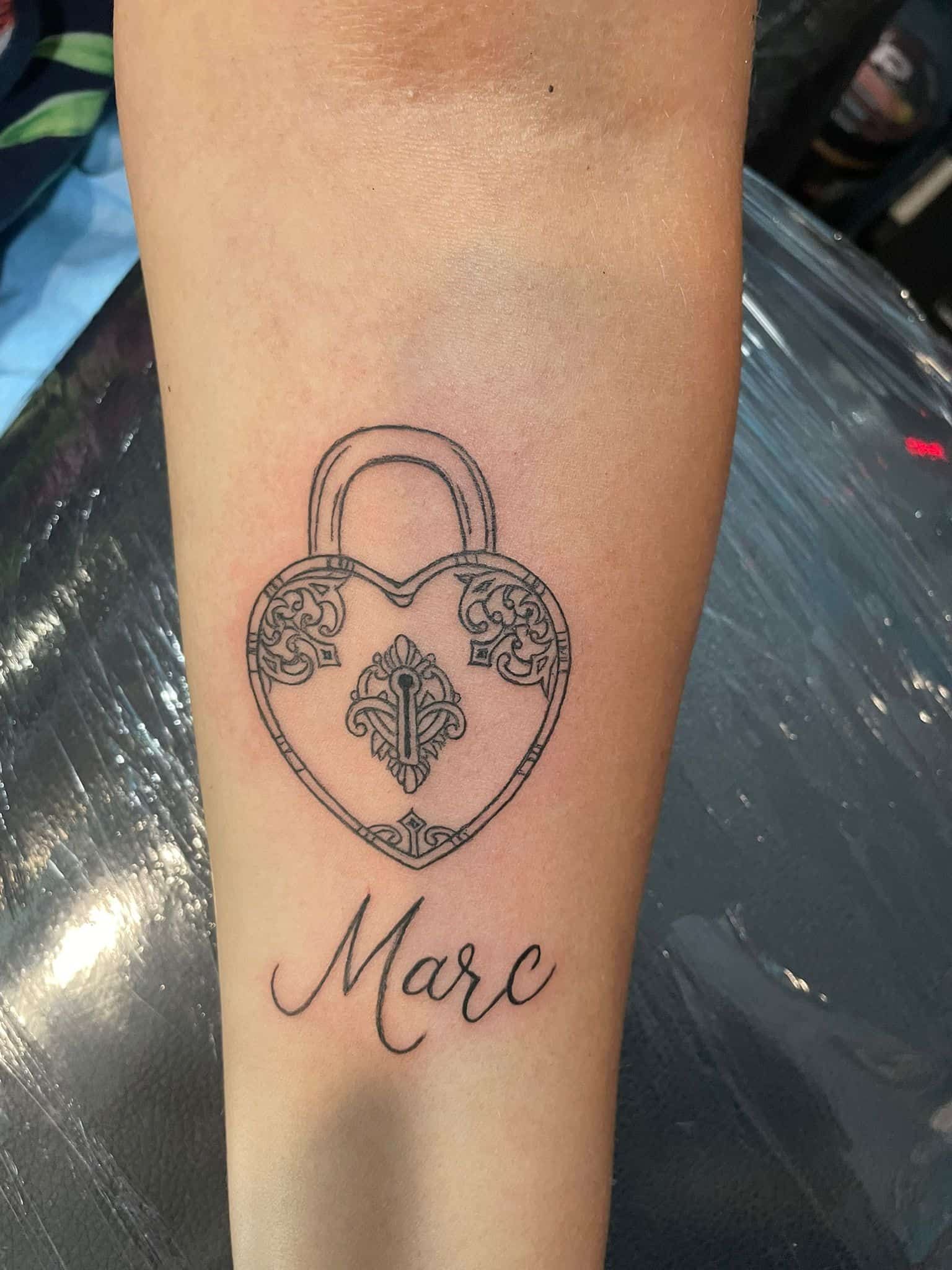 Tatuaje de un candado en forma de corazón con el nombre