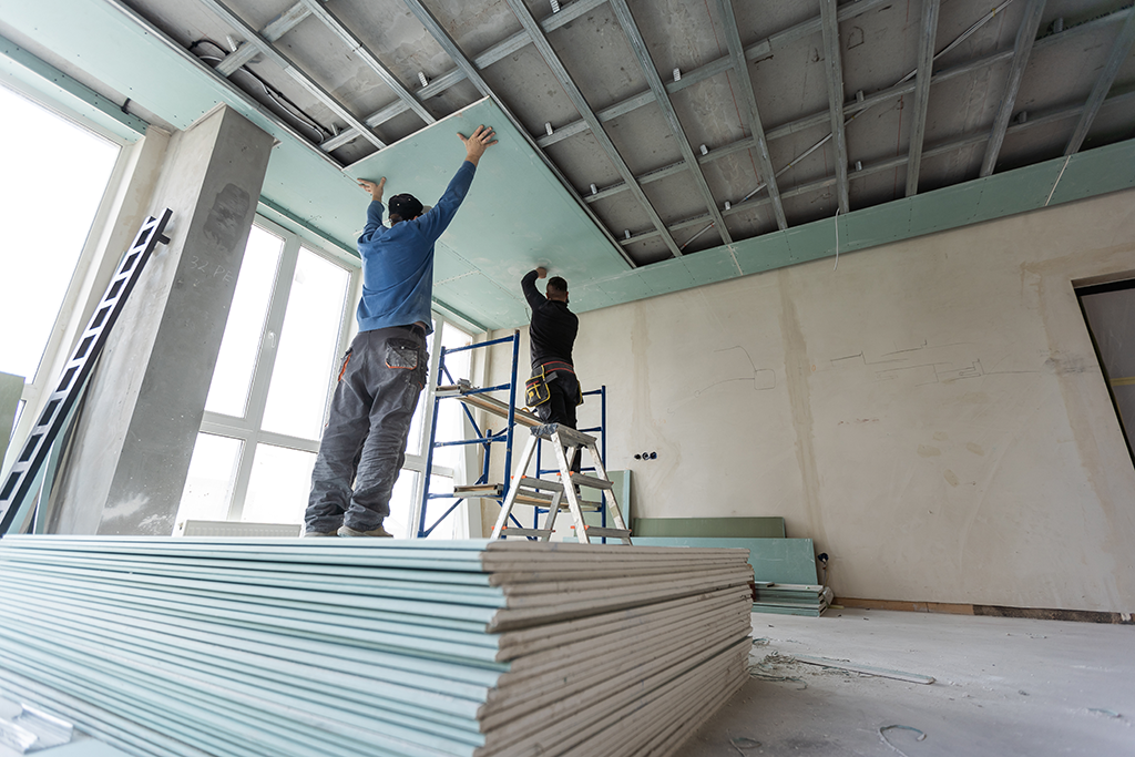 Travaux d'installation de plafond par des travailleurs dans la construction