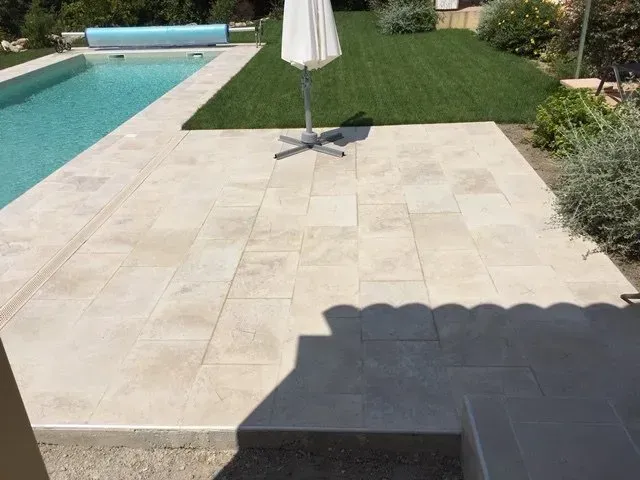 Terrasse en carrelage extérieur près d'une piscine