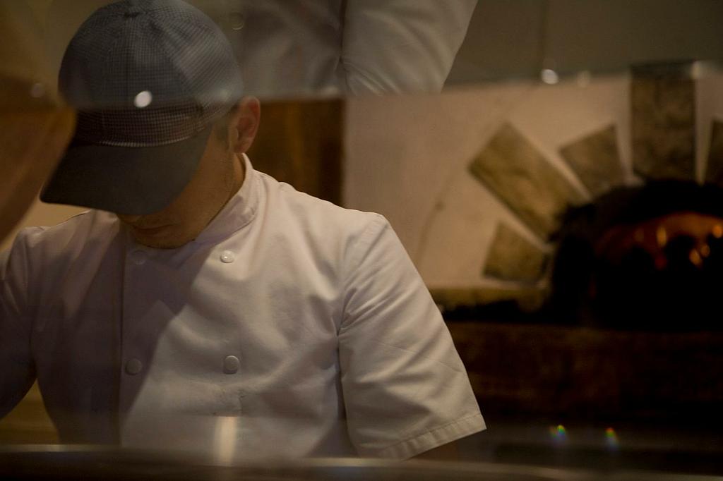 Un pizzaïolo derrière son plan de travail