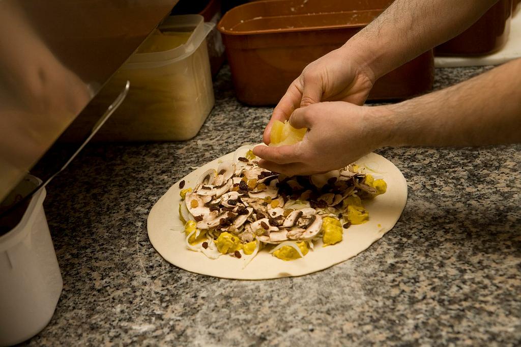 Mise en place de la garniture d'une pizza