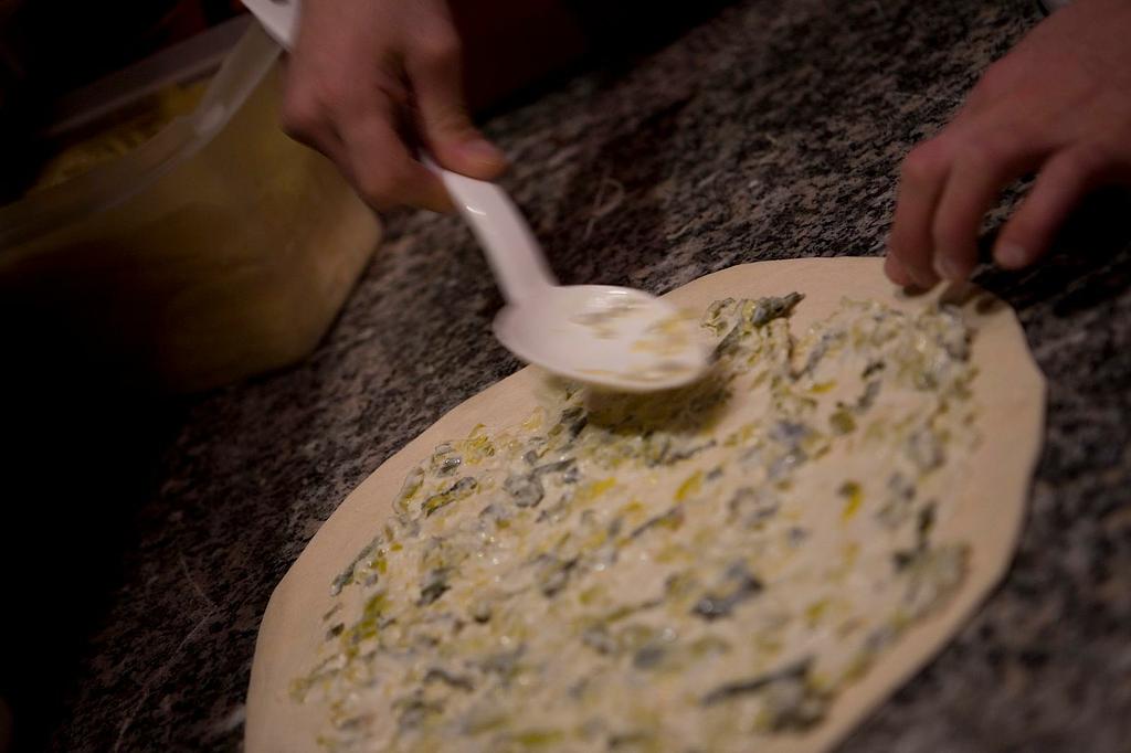 Réalisation d'une pizza à base crème et poireaux