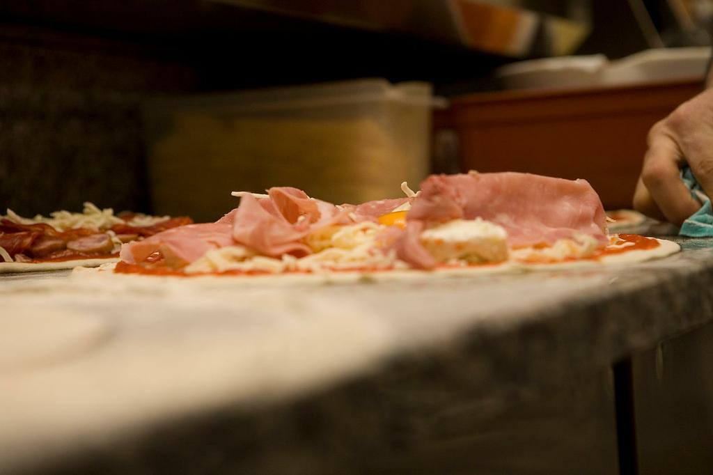 Pizza vue depuis le bord de la table, juste avant d'être mise au four